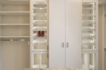 Luxury Walk-in Closet with Glass Display Case for Shoes and purses. Slab doors for other less elegant items. Walk-in Closet complete with island for jewelry.