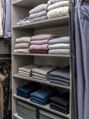 Storm or Fog Grey Walk-in Closet with grey woodgrain door and drawer faces. LED Lighting along the system. His and her side with shoe shelving, hanging and upper storage