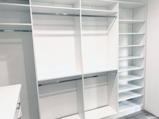 White walk-in closet system with drawers and doors. Lots of hanging and some shoe storage. Shaker drawer and door faces.