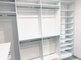 White walk-in closet system with drawers and doors. Lots of hanging and some shoe storage. Shaker drawer and door faces.