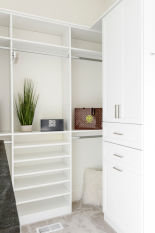 Walk-in Closet with Shaker Doors and Dresser Drawer Bank and laundry wire basket.