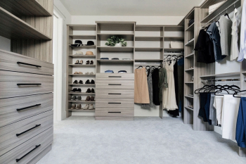 Wood-grain-finish-walk-in-closet-with-drawer-banks-hanging-sections-and-more