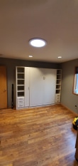 White queen murphy bed with shaker face styles. Side cabinets with open shelving and drawers below