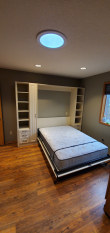 White queen murphy bed with shaker face styles. Side cabinets with open shelving and drawers below