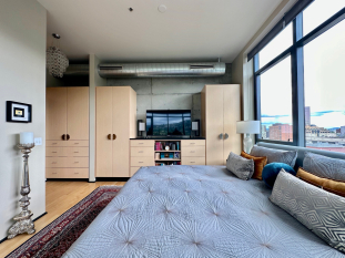External closet wardobe custom designed with drawers and hanging behind doors. TV unit on top.
