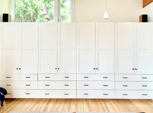 Custom external wardrobe closet with white shaker doors. Slab drawer faces with double handles black matte.
