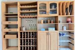 Custom pantry cabinets and storage with maple finish. Glass reed doors. Pull-out trays, adjustable shelving, wine rack storage, wine glass storage, and pull-out wire basket