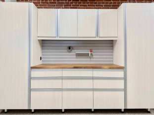 Bianco custom garage cabinets with a butcher block american walnut countertop. Extruded aluminum handles. Slat wall for tool storage and organization. Big side cabinets and lots of drawer storage.