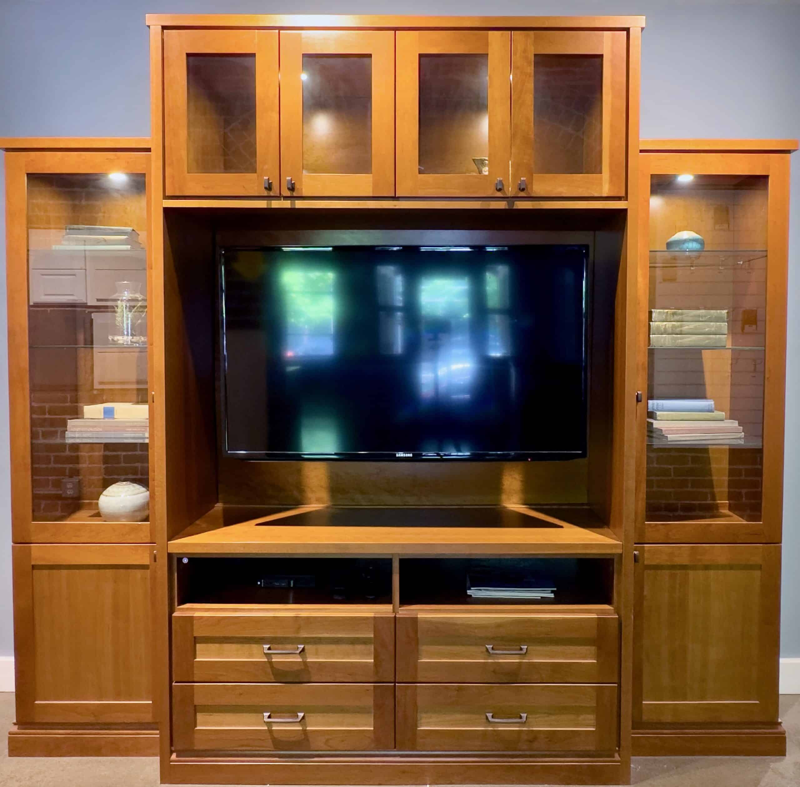 Custom Wood Entertainment Media Unit Center with glass doors, puck LED lighting, 5 piece shaker doors, glass shelves and drawers.
