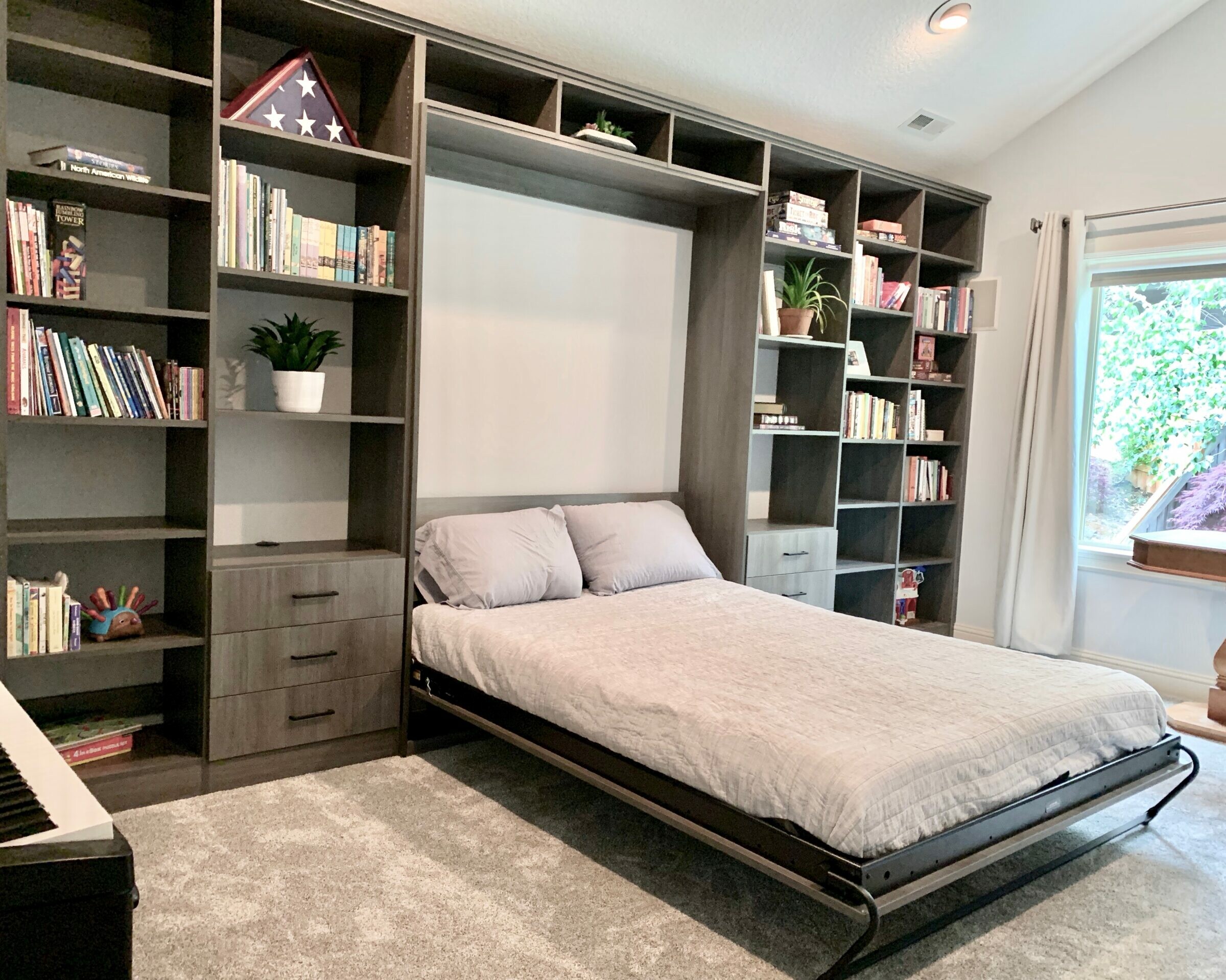 Queen Murphy Bed Built-in Wall to Wall with drawers on each side and book shelving floor to ceiling and wall to wall. Pewter Pine finish.