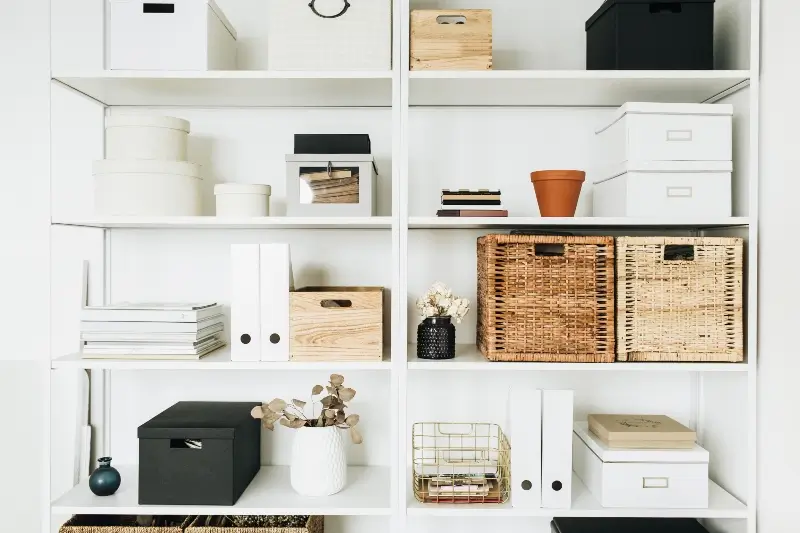 Modern home office cabinet storage with white storage shelves holding boxes, eucalyptus, and decorations