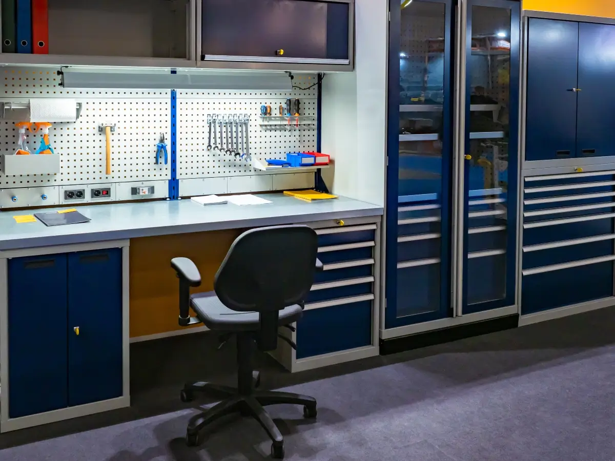 A custom-built garage workshop with storage, a workbench, rolling chair, and LED lighting