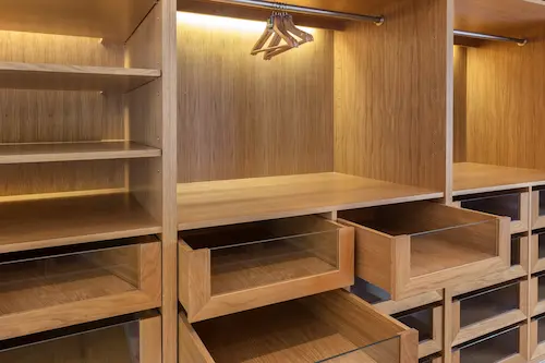 Custom-built wardrobe made with warm wood, with empty boxes
