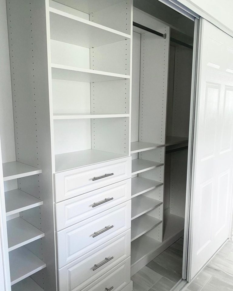 Custom reach-in closet with floor-based shelving and drawer system
