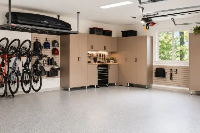Beige custom garage cabinet system featuring overhead rack storage and vertical bike rack installation in Portland, OR.