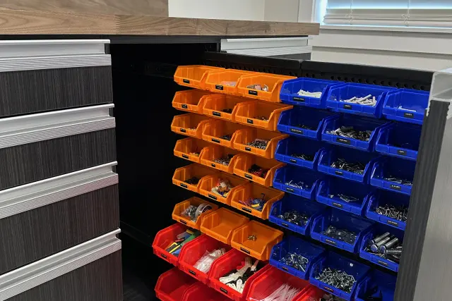 Custom pull-out garage cabinet organizer with color-coded hardware bins