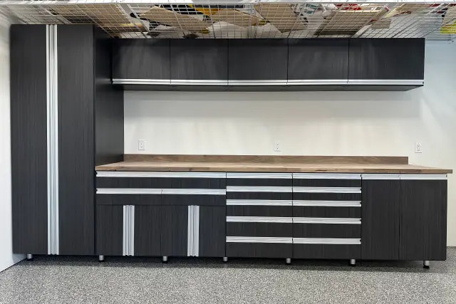 Dark woodgrain garage workbench and tool storage cabinet unit built by Portland Closet Company.